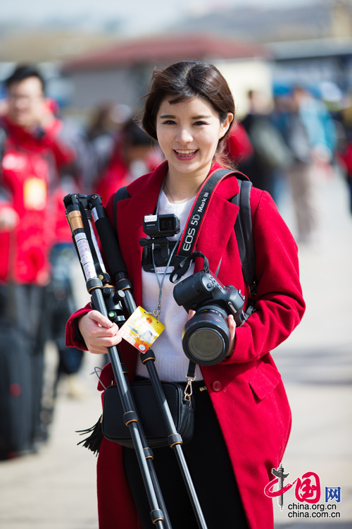 2016年兩會(huì)，人民大會(huì)大堂前，一位笑容燦爛的紅衣女記者正步入大會(huì)堂。中國(guó)網(wǎng) 鄭亮 攝