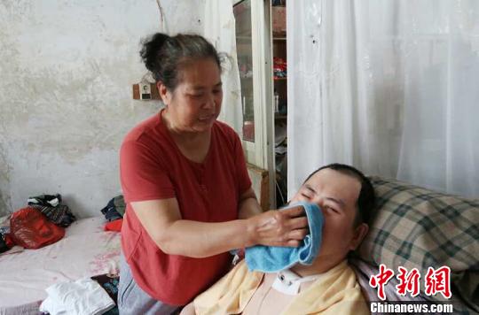 每次喂完食物后，梁青蘭都要仔細(xì)地幫兒子清理干凈?！∩忻鱾b 攝