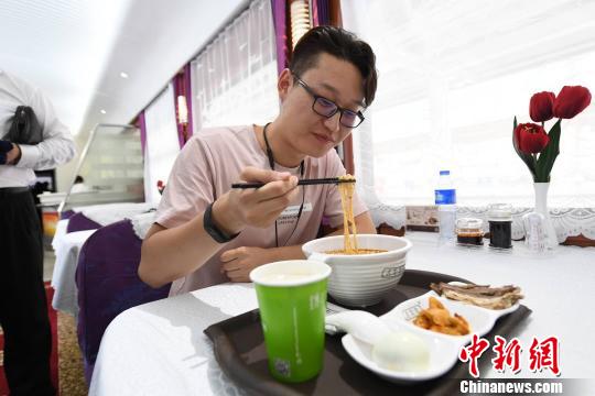 圖為旅客在列車上享用正宗牛肉面?！钇G敏 攝