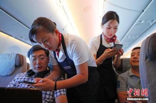 資料圖：乘務(wù)員們在客艙內(nèi)為旅客調(diào)試機上上網(wǎng)功能。<a target='_blank' ><p  align=