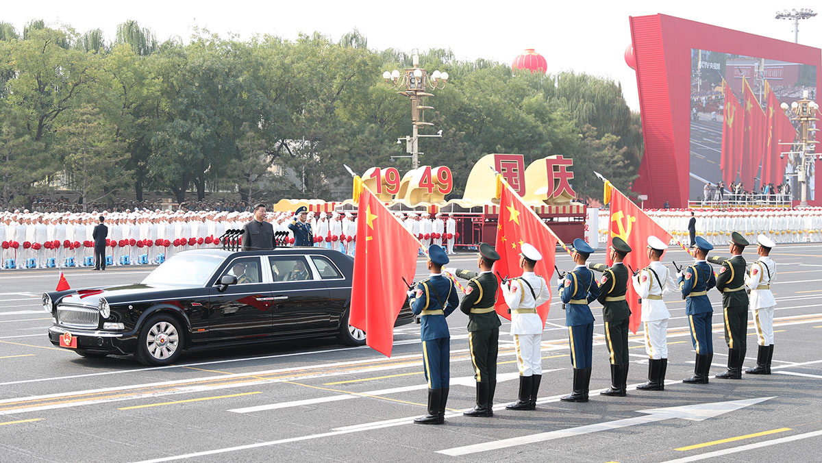 習(xí)近平驅(qū)車行進(jìn)至黨旗、國旗、軍旗前，向旗幟行注目禮